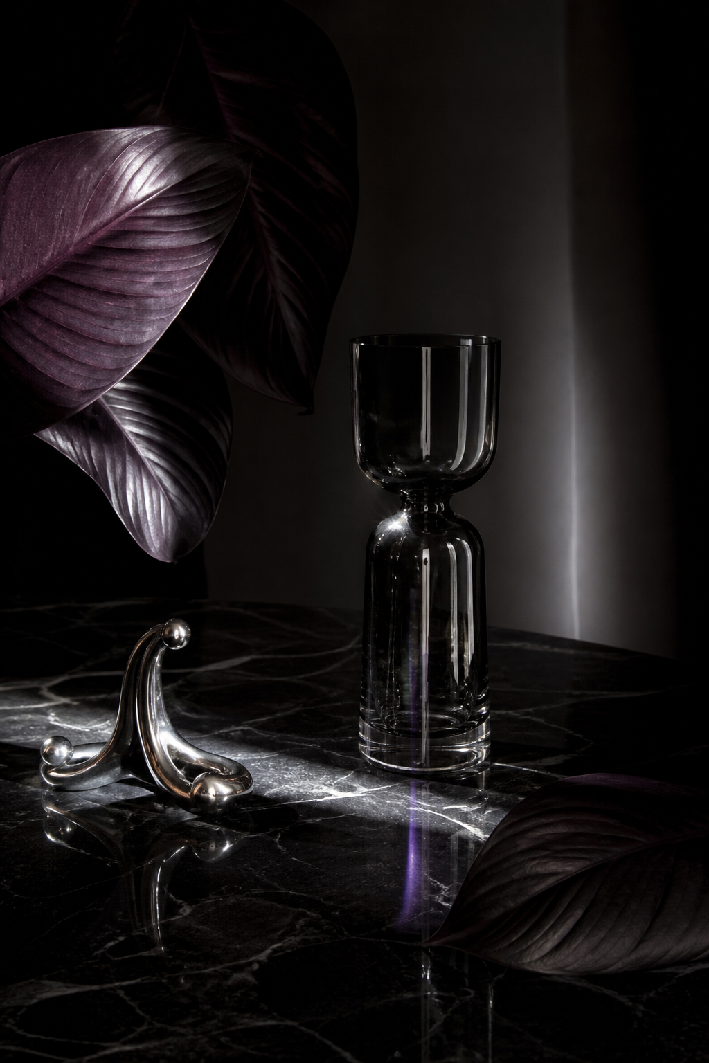 Naturaleza muerta oscura con cristal y hojas violetas